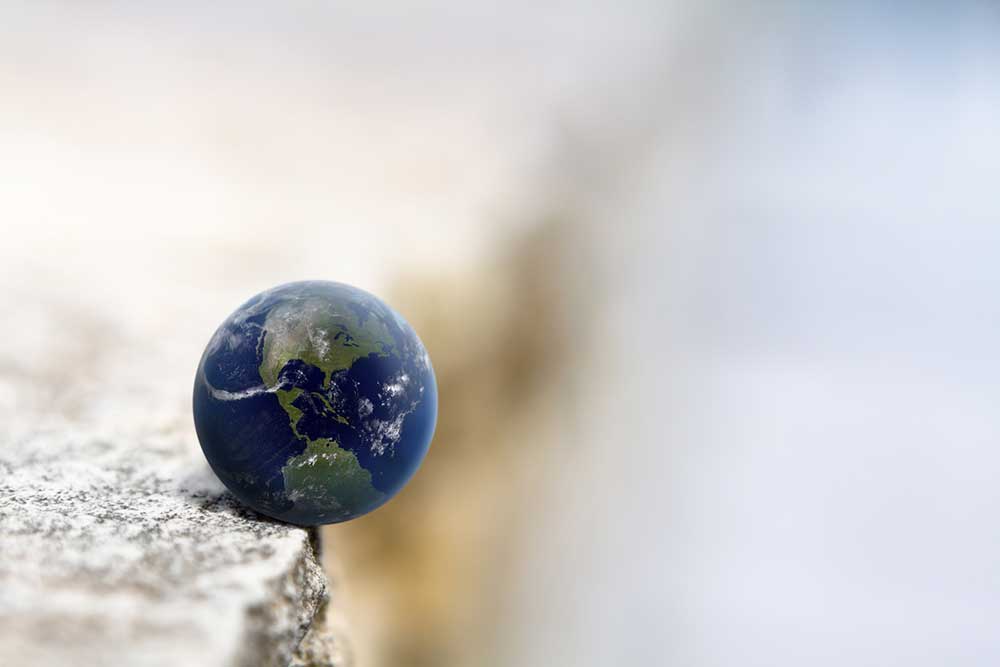 Model of the earth sitting on the edge of a cliff