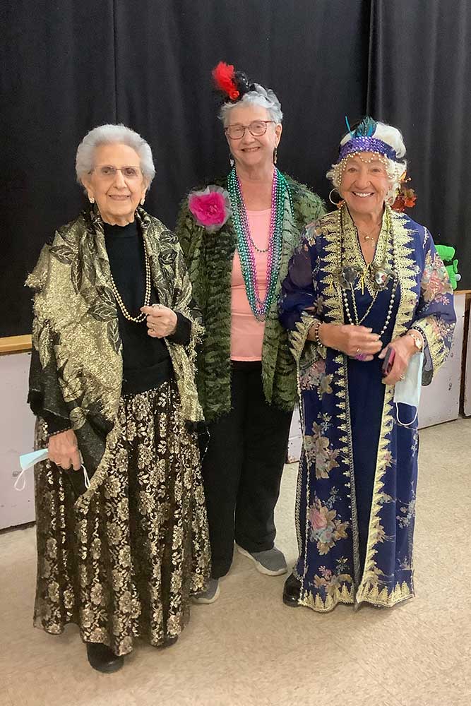 Three women in festive clothing smiling for the camera